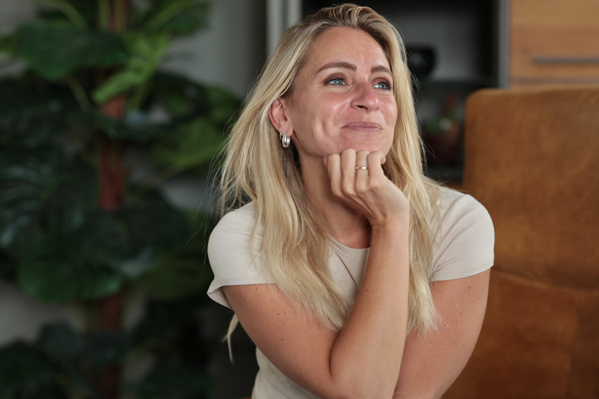 Vrouw zit rustig in gedachten in haar woonkamer